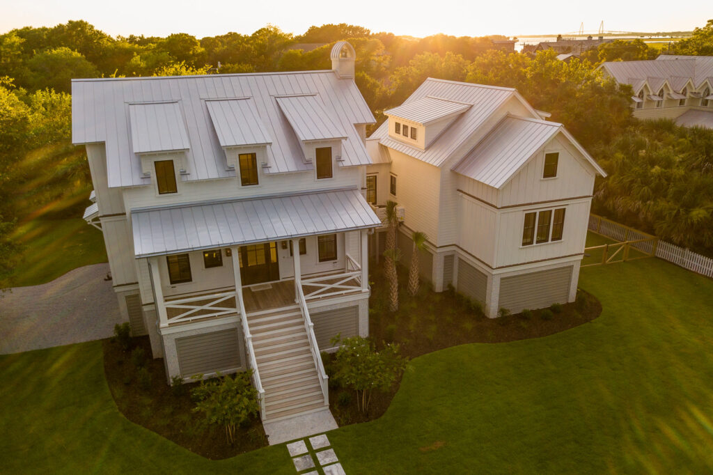 stunning large white home with steps leading to a porch and green grass in the year 