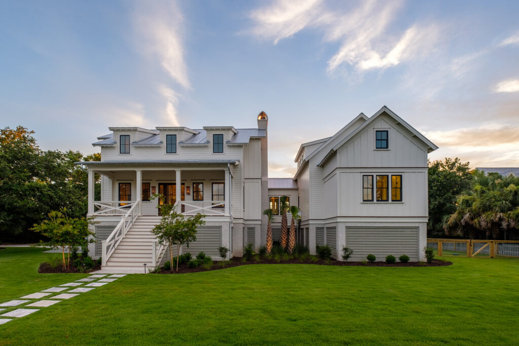 front view of newly renovated white home, stone pathway in front yard leading to steps - hiring a residential architect charleston sc