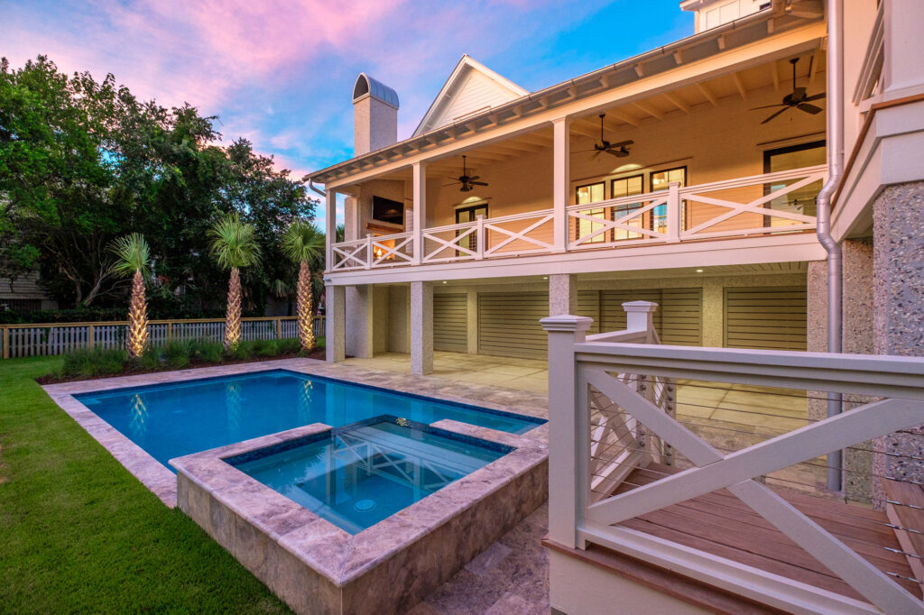 back side of white home with pool in backyard, lush green grass, palm trees - hiring a residential architect, charleston, SC