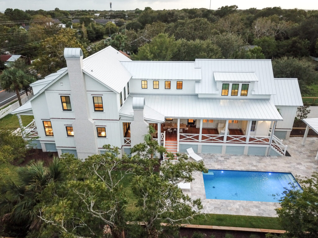 white home with pool surrounded by trees