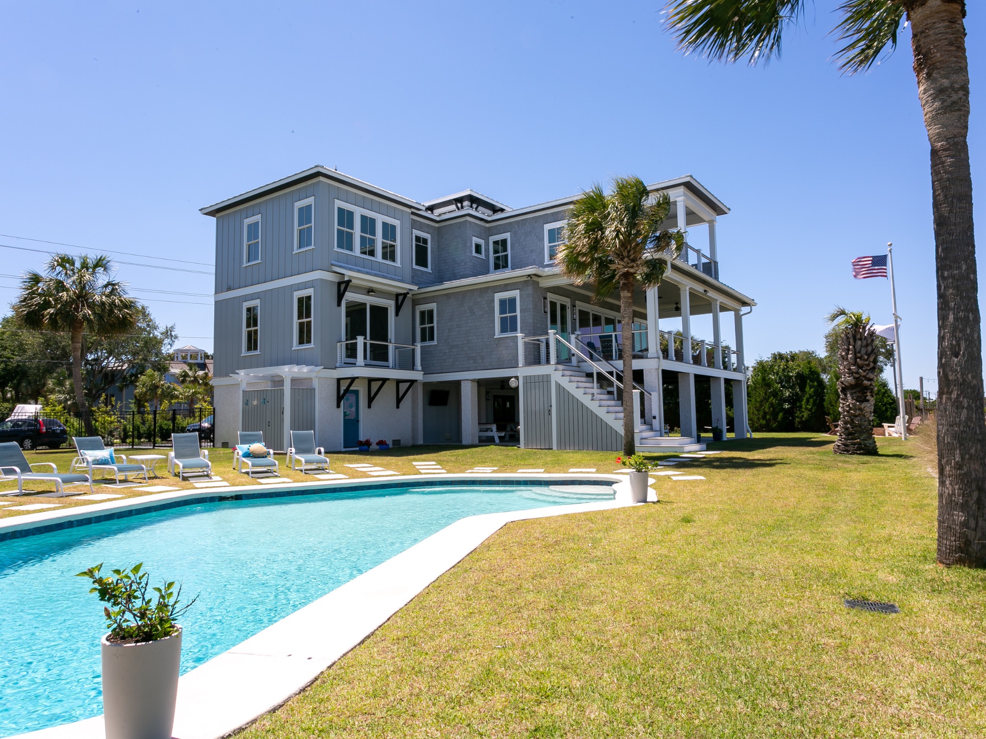 pool, flag pole and American Flag and two story grey home