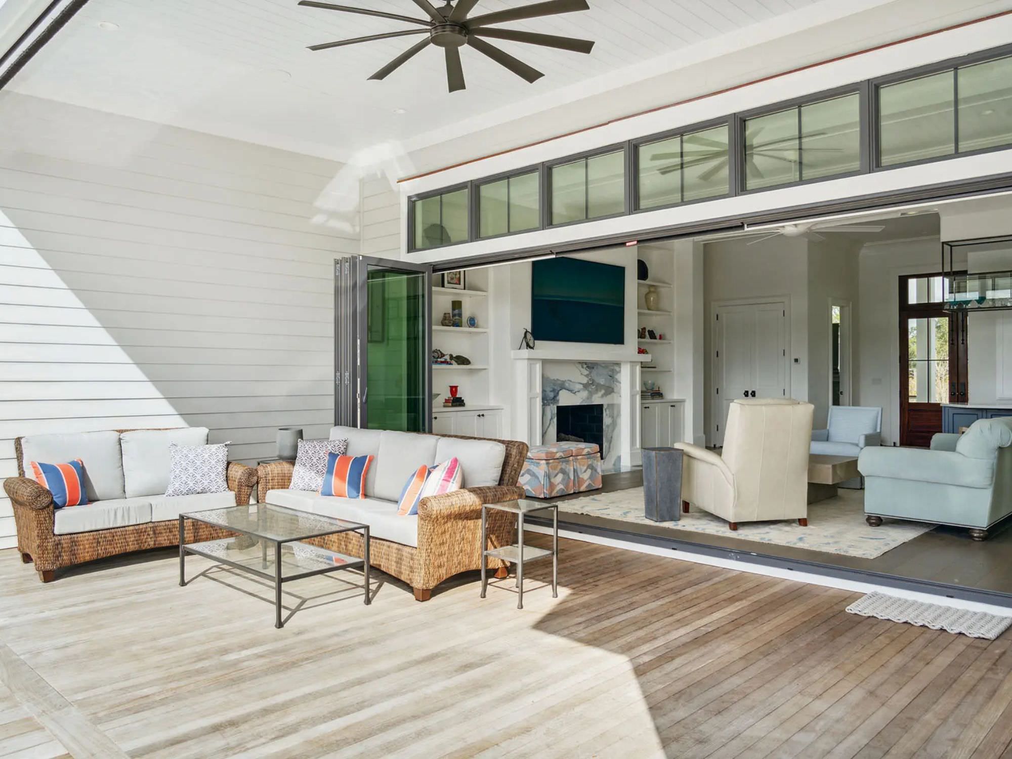 beautiful deck backing up to opened up glass doors looking in den of home - charleston architects