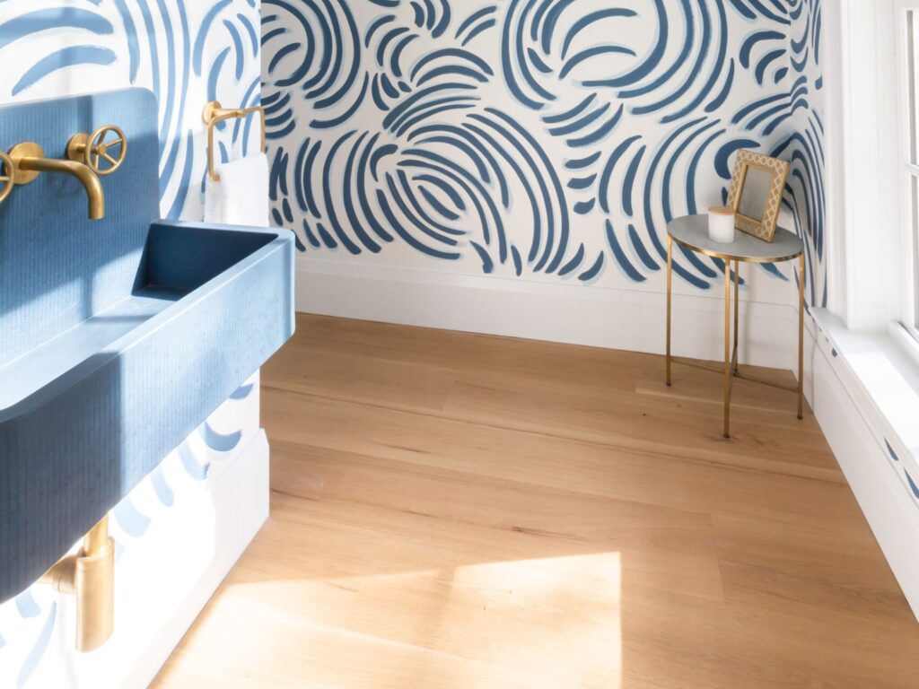 beautiful wallpaper and bathroom wink with gold fixtures