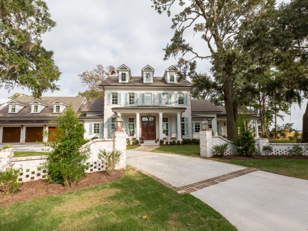large home with aqua shutters and white fence - home renovation architect